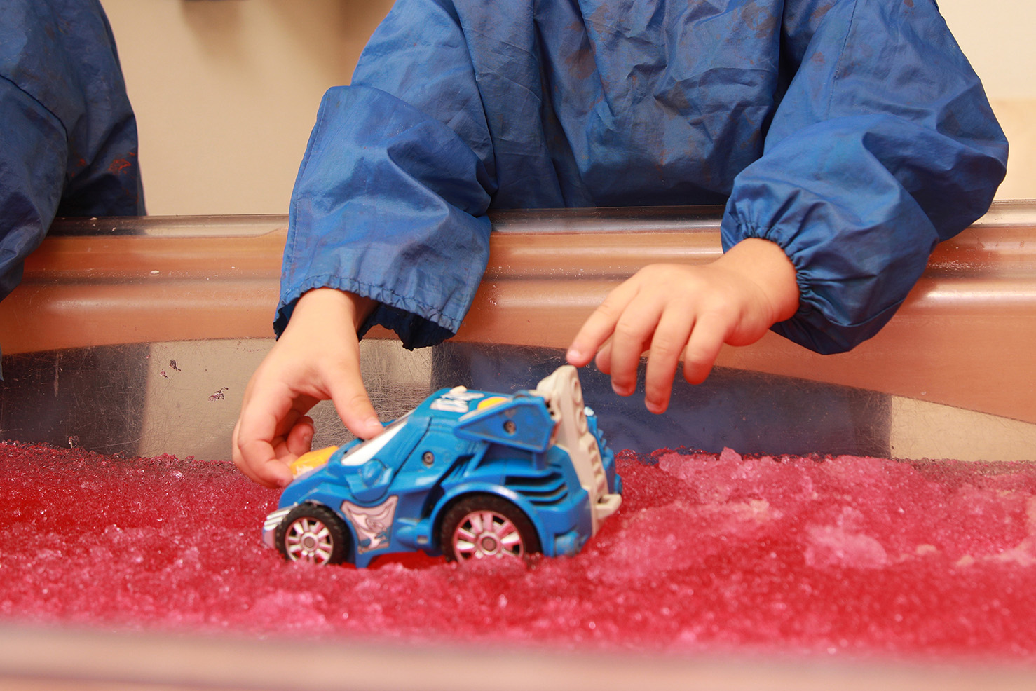 A young child exploring a sensory play tray