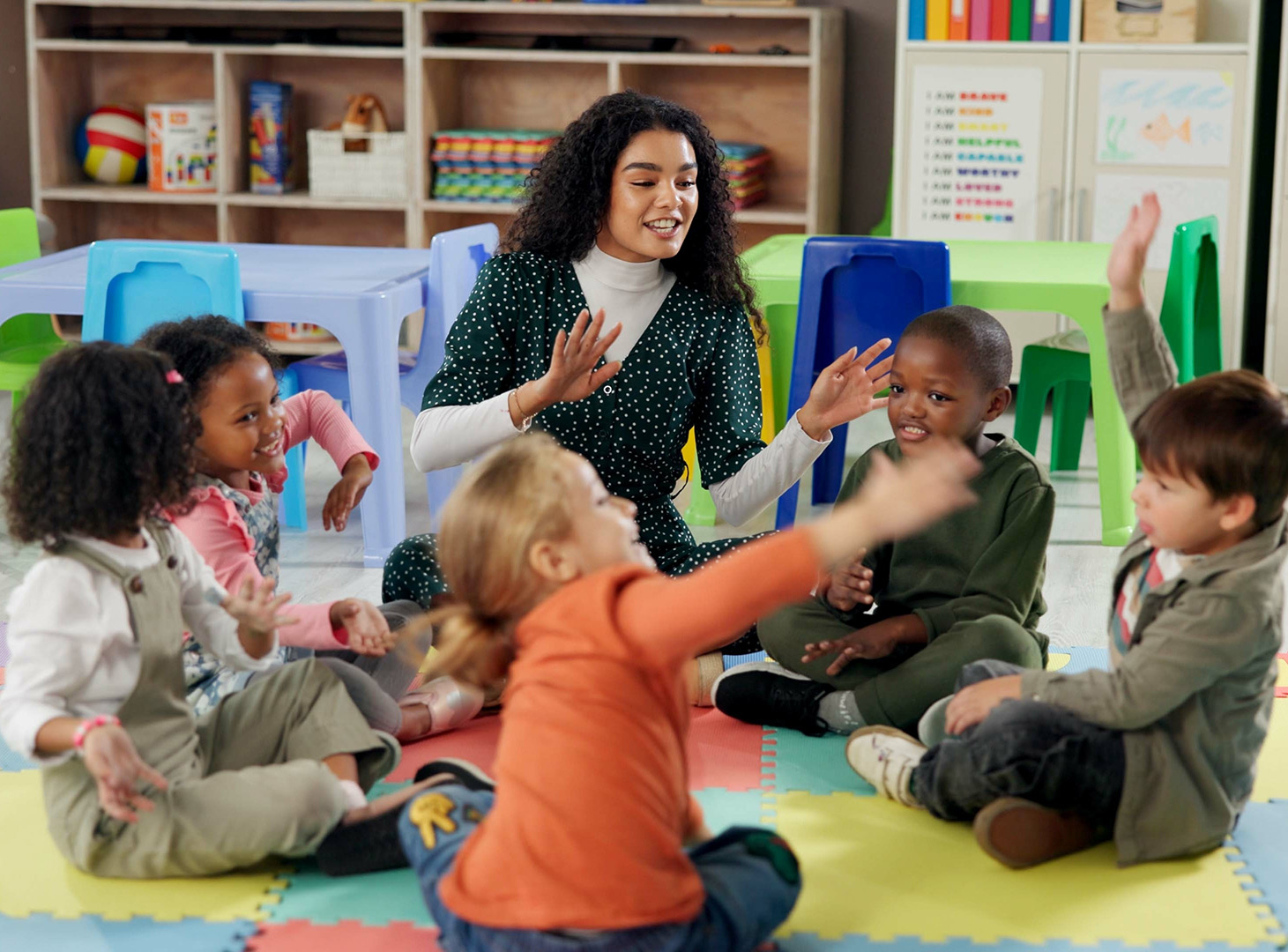 A nursery practitioner with a group of children